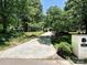 Long concrete driveway leading to a home, lined with lush trees and greenery offering plenty of privacy at 8200 Lansford Rd, Charlotte, NC 28277