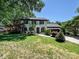 Inviting white brick home with a manicured lawn, black shutters, mature landscaping, and an attached garage at 8200 Lansford Rd, Charlotte, NC 28277