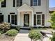 A close up of a home's front door featuring white columns and lush landscaping at 8200 Lansford Rd, Charlotte, NC 28277