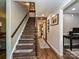 Hallway featuring hardwood floors and a staircase with natural wood handrail at 8200 Lansford Rd, Charlotte, NC 28277