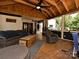 Spacious covered patio area with a lounge, ceiling fans, and wood flooring, perfect for outdoor relaxation at 8200 Lansford Rd, Charlotte, NC 28277