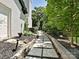 Beautiful stone walkway lining the side of the house with fresh landscaping and a small stone retaining wall at 8200 Lansford Rd, Charlotte, NC 28277