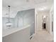 Hallway with gray walls, carpet flooring, and a modern decorative light fixture at 959 Robinson Rd, Gastonia, NC 28056