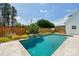Backyard pool with waterfall feature, landscaping, and a basketball hoop for poolside fun at 959 Robinson Rd, Gastonia, NC 28056
