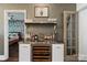 Stylish wet bar with marble countertop, wine fridge, and decorative shelving at 1025 Ardsley Rd # 103, Charlotte, NC 28207