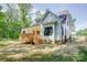 Rear view of a charming white two-story house, complemented by a spacious deck overlooking the landscaped backyard at 1030 Little Cowgirl Ln, Cleveland, NC 27013