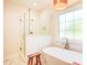 Bright bathroom featuring a glass-enclosed shower, soaking tub, and bronze fixtures at 1030 Little Cowgirl Ln, Cleveland, NC 27013