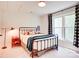 Charming bedroom featuring a wrought-iron bed, side table, and window with buffalo check curtains at 1030 Little Cowgirl Ln, Cleveland, NC 27013