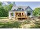 Home exterior featuring a spacious wood porch, surrounded by green space and trees for a private setting at 1030 Little Cowgirl Ln, Cleveland, NC 27013