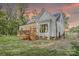 Charming home features a spacious deck, ideal for outdoor entertaining, set against a backdrop of a stunning colorful sunset sky at 1030 Little Cowgirl Ln, Cleveland, NC 27013
