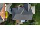 Aerial view of a home with a well-maintained roof, lush landscaping, a backyard patio, and a car in the driveway at 1116 Crooked River Dr, Waxhaw, NC 28173