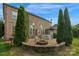 Spacious backyard with a brick patio, fire pit, mature trees, and well-maintained lawn for outdoor enjoyment at 1116 Crooked River Dr, Waxhaw, NC 28173