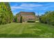 Large backyard featuring a brick patio, a fire pit area, lush greenery, providing an ideal space for outdoor gatherings at 1116 Crooked River Dr, Waxhaw, NC 28173
