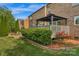 Serene backyard featuring an outdoor gazebo dining area surrounded by landscaped greenery and a brick house at 1116 Crooked River Dr, Waxhaw, NC 28173