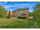 Landscaped backyard featuring lush green grass, a brick house, and a gazebo with a dining area at 1116 Crooked River Dr, Waxhaw, NC 28173