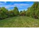Expansive backyard with lush green grass, mature trees, offering a serene and private outdoor space at 1116 Crooked River Dr, Waxhaw, NC 28173
