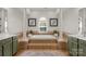Elegant bathroom with a sunken tub, decorative columns, and tiled surround and matching green cabinets at 1116 Crooked River Dr, Waxhaw, NC 28173