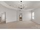 Spacious bedroom featuring a tray ceiling, modern chandelier and doorway to an adjoining room at 1116 Crooked River Dr, Waxhaw, NC 28173