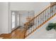 Elegant foyer with hardwood floors, a staircase with wrought iron spindles, and a view into the dining room at 1116 Crooked River Dr, Waxhaw, NC 28173