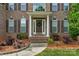 Welcoming front door with white pillars and beautiful landscaping leading to the front entrance of the house at 1116 Crooked River Dr, Waxhaw, NC 28173
