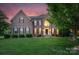 A beautiful two-story brick home featuring classic architecture with an arched window and well-kept lawn at 1116 Crooked River Dr, Waxhaw, NC 28173