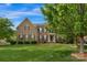 Charming brick two-story home with a lush green lawn and mature landscaping creating a welcoming curb appeal at 1116 Crooked River Dr, Waxhaw, NC 28173