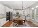 Modern kitchen with white cabinets, stainless appliances, and a central dining area at 1116 Crooked River Dr, Waxhaw, NC 28173
