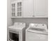 Modern laundry room with white cabinets and front-loading washer and dryer at 1116 Crooked River Dr, Waxhaw, NC 28173