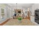 Bright open-concept living room featuring hardwood floors, columns, and a stone accent wall at 1116 Crooked River Dr, Waxhaw, NC 28173