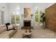 Spacious living room with a stone fireplace, large windows, and comfortable seating area at 1116 Crooked River Dr, Waxhaw, NC 28173