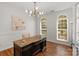 Bright home office with hardwood floors, natural light from arched windows, and a stylish, modern chandelier at 1116 Crooked River Dr, Waxhaw, NC 28173