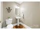 Cozy half bath with pedestal sink, white toilet, and neutral walls at 1200 Churchill Downs Dr, Waxhaw, NC 28173