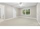 Neutral spare bedroom featuring a ceiling fan, a window overlooking a wooded area, and an ensuite bathroom at 1200 Churchill Downs Dr, Waxhaw, NC 28173