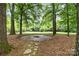 Stone fire pit area surrounded by mature trees, perfect for outdoor entertaining at 1200 Churchill Downs Dr, Waxhaw, NC 28173