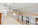 Second floor hallway featuring natural light, decorative railing, neutral carpet and views to the living room below at 1200 Churchill Downs Dr, Waxhaw, NC 28173