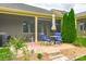 Charming back patio with outdoor seating, lush landscaping, and a screened porch, creating an inviting outdoor living space at 121 Martingale Ave, Mooresville, NC 28115