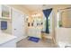 Bright bathroom featuring a vanity, shower with glass door, and large window with blue accent curtain at 121 Martingale Ave, Mooresville, NC 28115