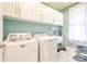 Bright laundry room features sleek white cabinets above Maytag washer and dryer, with a tiled backsplash and a large window at 121 Martingale Ave, Mooresville, NC 28115