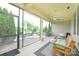 Inviting screened porch featuring cozy seating, ceiling fan, and views of the landscaped backyard and outdoor patio at 121 Martingale Ave, Mooresville, NC 28115