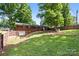Lush backyard with a brick house, featuring a spacious lawn and mature trees for outdoor enjoyment at 137 Deal Ln, Statesville, NC 28677