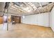 Unfinished basement with concrete flooring, exposed ceiling, wood paneling, and storage space at 137 Deal Ln, Statesville, NC 28677
