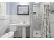 Bathroom with pedestal sink, toilet, and walk-in shower, adorned with elegant marble tiling for a spa-like feel at 137 Deal Ln, Statesville, NC 28677