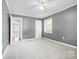 Comfortable carpeted bedroom with a window, ceiling fan, and a door leading to the hallway at 137 Deal Ln, Statesville, NC 28677