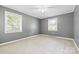 Relaxing bedroom with neutral carpet, two windows, a ceiling fan, and gray walls, creating a serene retreat at 137 Deal Ln, Statesville, NC 28677