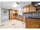 Well-lit kitchen featuring wooden cabinets, stainless appliances, and tiled flooring at 137 Deal Ln, Statesville, NC 28677