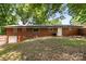 Brick home exterior with a walkout basement, complemented by a well-maintained lawn and mature trees at 137 Deal Ln, Statesville, NC 28677