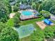 Aerial view of community amenities including pool, tennis court, basketball court and playground amid lush landscaping at 16430 New Providence Ln, Charlotte, NC 28277