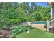 Serene backyard featuring a putting green, pool, and lush landscaping for ultimate relaxation and recreation at 16430 New Providence Ln, Charlotte, NC 28277