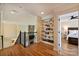 Bright bonus room featuring a stone fireplace, built-in bookshelves, and hardwood floors at 16430 New Providence Ln, Charlotte, NC 28277