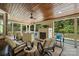 Inviting covered patio featuring a stone fireplace, comfortable seating, and wooded views at 16430 New Providence Ln, Charlotte, NC 28277